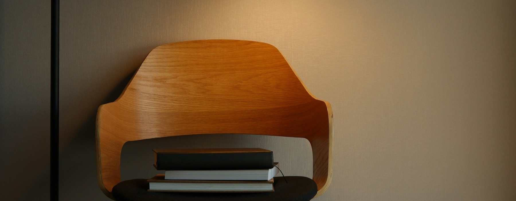 a chair with books and a lamp