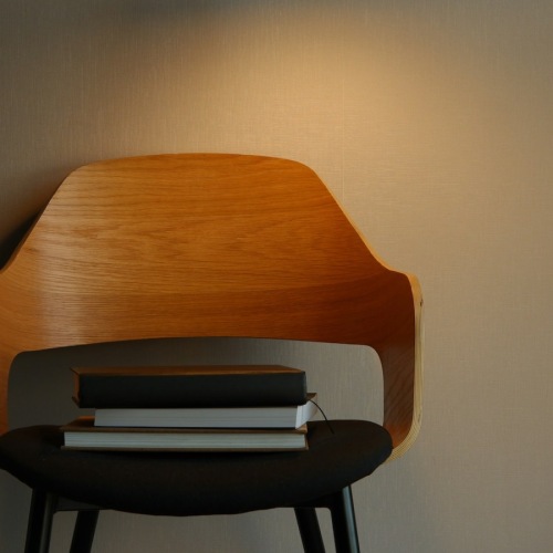 a chair with books and a lamp